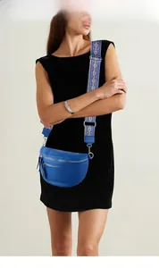 Blue leather crossbody bag with ethnic pink woven strap on a female model