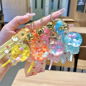 Dettaglio di quattro portachiavi a forma di lecca-lecca colorati con paillettes e campanelli