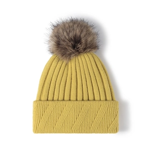 Mustard yellow ribbed knit beanie with large faux fur pom-pom and thick folded cuff