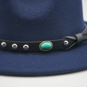 Dettaglio di un cappello in feltro blu navy con pietra turchese e borchie argento