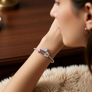 Detail of vintage silver cuff bracelet with purple floral zircon and white enamel flower