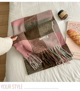 Detailed close-up of soft plaid scarf with fringe on a cozy winter background