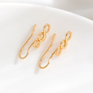 Macro view of gold-plated infinity loop earrings with a polished mirror finish