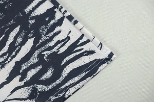 Detailed view of the zebra print fabric with high-quality stitching on the wide leg pants