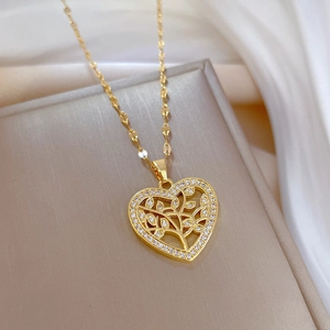Golden heart tree of life necklace with crystals on soft white silk background