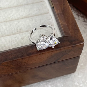 Detailed macro of silver adjustable ring with heart and emerald cut cubic zirconia stones