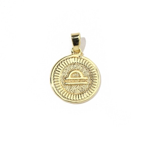 Detailed macro view of 18k gold Libra zodiac charm with radiant relief texture