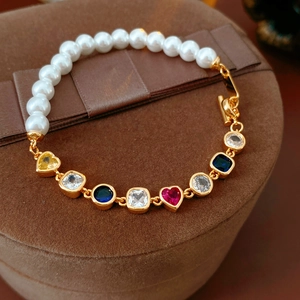 Detail eines Vintage-Herz-Perlenarmbands mit bunten Zirkonia auf braunem Samtschmuckkästchen