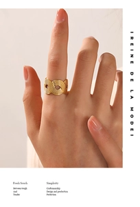 Close-up of golden hollow wave textured wide band ring on finger for a stylish look