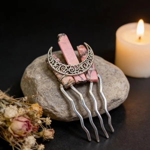 Detail of metal hair comb with pink natural stones and crescent moon on grey stone base