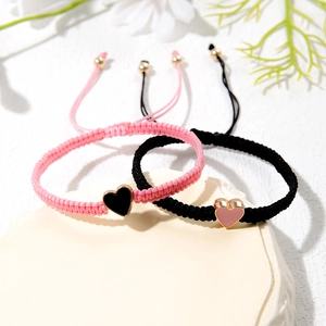 Detail of adjustable heart charm bracelets for couples on minimalist stone base