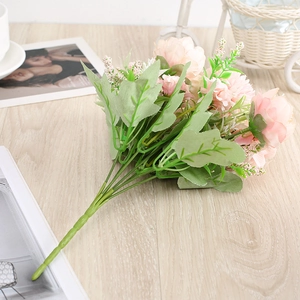 Detailed view of pink artificial flower bouquet with realistic leaves on a wooden table