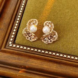 Detailopname van vintage gouden oorbellen met parels op een donkere fluwelen achtergrond