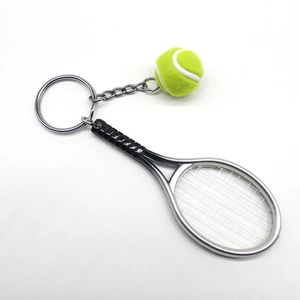 Detailed shot of mini tennis racket keychain with yellow ball and silver metal ring
