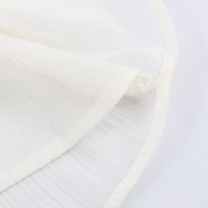 Close-up of white ruffled blouse showing lightweight translucent fabric with vertical stripes