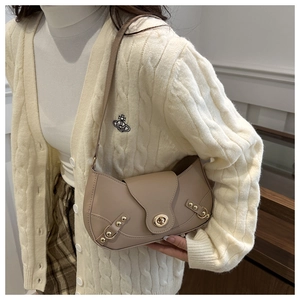 Detail of khaki leather crescent underarm bag with gold lock on beige knitwear outfit