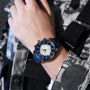 Stylish men's watch with blue silicone strap and black metal case shown on male wrist