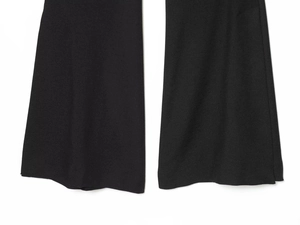 Detailed view of black flare pants featuring high-quality woven fabric and hem stitching