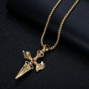 Golden Tibetan vajra pendant necklace with red crystal inlay on black background