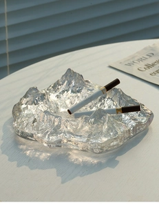 Macro shot of mountain-shaped glass ashtray with artistic light and shadow detail