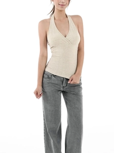 Detail of light beige ribbed knit fabric on a slim fit halter neck top with deep V-neckline