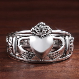 Bague Claddagh classique en argent avec mains tenant un cœur couronné sur fond bois
