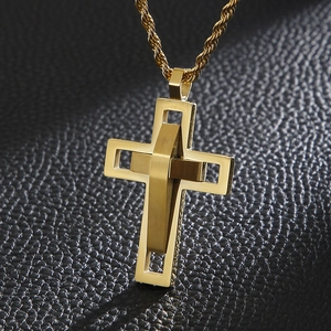 Macro shot of double-layered gold cross pendant necklace on black textured leather surface