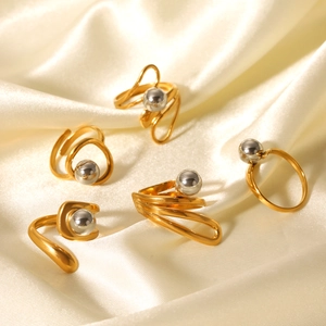 Two-tone stainless steel spherical rings set on silk fabric for a minimalist industrial look