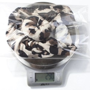 Baby leopard print knot headband on a scale weighing 29.0g in shipping packaging