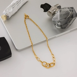 Detail of layered gold stainless steel chain necklace with interlocking oval links
