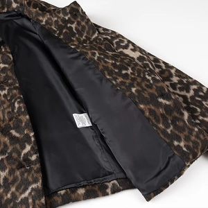 Dettaglio della giacca leopardata con fodera nera liscia ed etichetta delle istruzioni