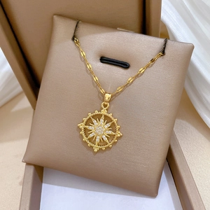 Golden sunburst star necklace with sparkling cubic zirconia on a luxury jewelry cushion