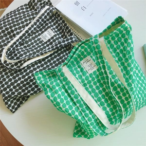 Detailed close-up of polka dot canvas tote bags with reinforced white shoulder straps