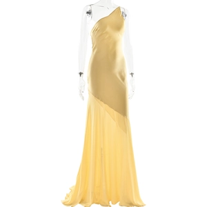 Detail of yellow one-shoulder evening gown with sheer mesh stitching and floor-length hem