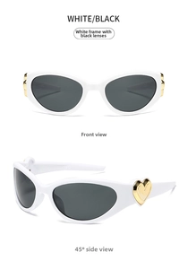 Close-up of white cat-eye sunglasses with gold heart detail and dark gray lenses