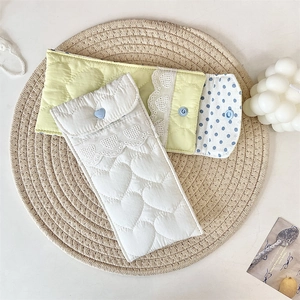 Detail of quilted heart pattern and lace trim on soft fabric eyewear storage bags