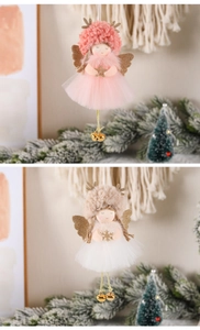 Close-up of Christmas angel ornaments in pink and beige with gold bells and soft yarn