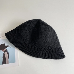 Detailed macro view of the classic cable knit texture on a black summer fisherman hat