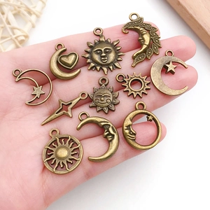 Set di ciondoli a forma di sole luna e stella in bronzo antico mostrati sul palmo