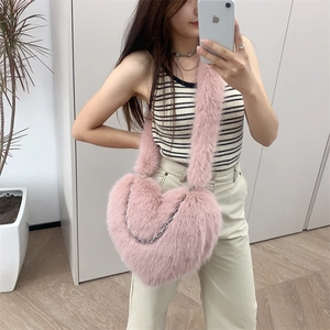 Pink heart-shaped plush crossbody bag with silver chain detail and fuzzy shoulder strap