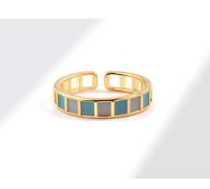 Detail of gold-plated ring featuring alternating blue and grey enamel geometric patterns