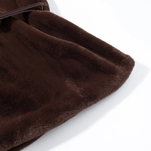 Gros plan sur le gilet en fausse fourrure marron foncé avec détails de bordure en cuir