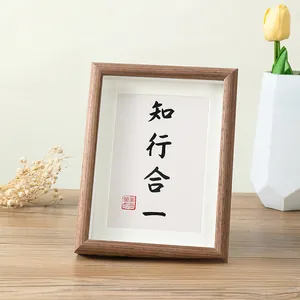 Detail of Nordic wooden photo frame with calligraphy art and white matting on a desk