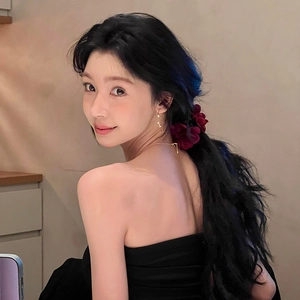 Pince à cheveux fleur en tissu rouge foncé sur modèle pour coiffure élégante