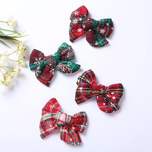 Détail de barrettes de Noël avec nœuds à carreaux rouges et verts et motifs de flocons