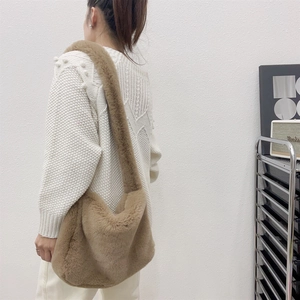 Plush brown faux fur tote bag with wide strap styled with a white knit sweater