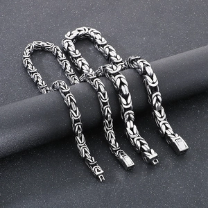 Men's silver-toned Byzantine chain necklaces with premium fold-over clasps on dark display