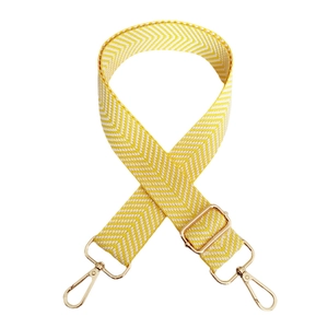 Close-up of yellow and white herringbone woven strap with adjustable gold lobster clasps