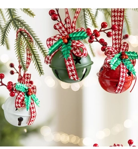 Close-up of red, green, and white metal Christmas bells with holly and berry details