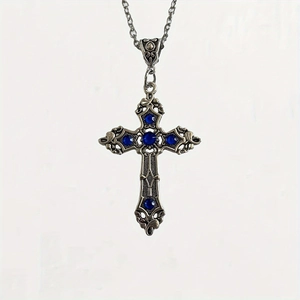 Detail of vintage silver gothic cross necklace featuring intricate blue gemstones